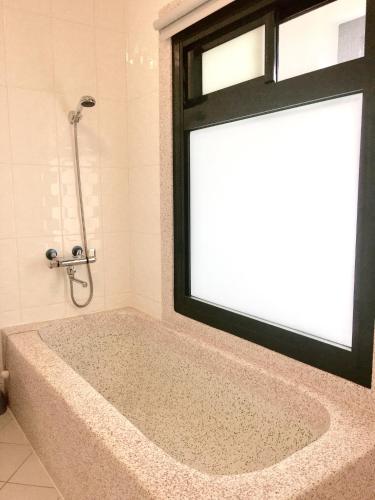 a bath tub with a window in a bathroom at Summer Homestay in Kenting