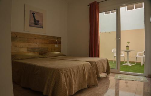 コティージョにあるApartamento luminoso a 200m de lagos de cotilloのベッドルーム1室(ベッド1台、大きな窓付)