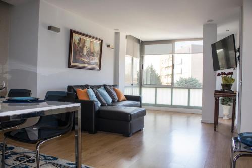 a living room with a black couch and a tv at Amazing Amial in Porto