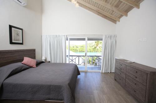 a bedroom with a bed and a large window at The Moxy in English Harbour Town