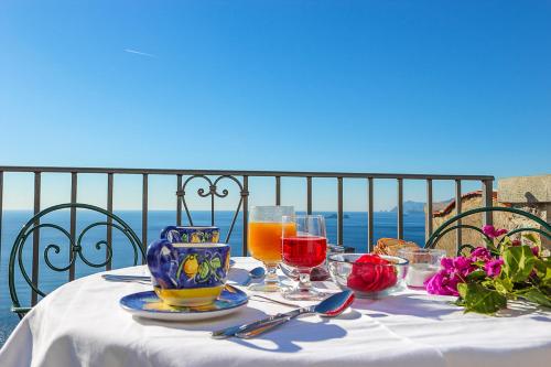 a table with a plate of food and drinks on it at Villa Il Frantoio and Lilmar in Praiano