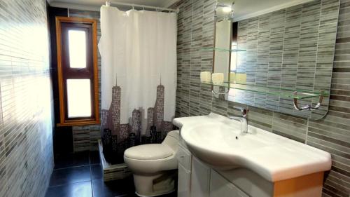 La salle de bains est pourvue d'un lavabo, de toilettes et d'une fenêtre. dans l'établissement Hospedaje Las Animas Valdivia, à Valdivia
