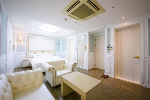 a living room with a bed and a couch at Gangneung Donga Hotel in Gangneung