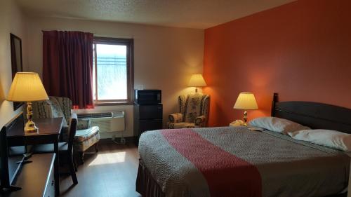 a hotel room with a bed and a desk and a window at Motel 6-Saukville, WI in Saukville