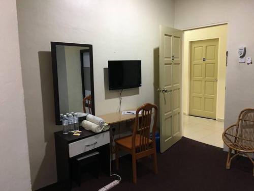 a room with a desk with a computer and a mirror at Kerteh Inn in Kertih