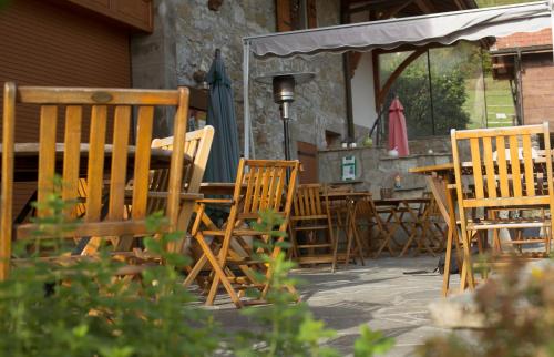 a group of wooden chairs and tables in a patio at Le Bonheur dans le Pré in Lucinges