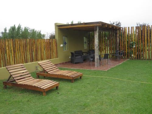 a backyard with two chairs and a gazebo at Posada del Santo Green & Rest - Cabañas in Salta