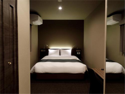 um quarto com uma cama grande e lençóis brancos em Act Hotel Roppongi em Tóquio