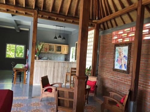 a living room with a brick wall and a kitchen at Kayu Tua Villa in Uluwatu