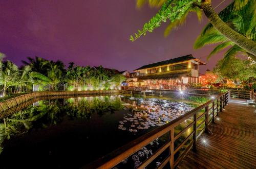 a hotel with a pond in front of a building at Hoi An Eco Lodge & Spa in Hoi An