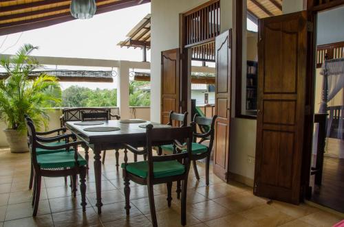 a dining room with a table and chairs at Villa Tara in Hikkaduwa