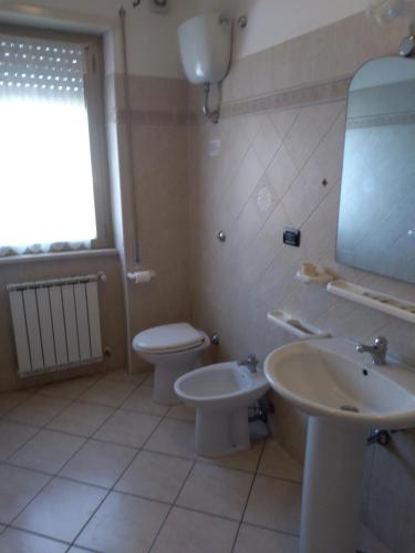 a bathroom with a sink and a toilet and a mirror at Hotel Grazia Ristorante in LʼAquila