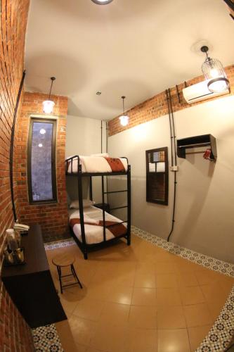 a room with two bunk beds in a brick wall at JQ Ban Loong Boutique Hotel in Ipoh