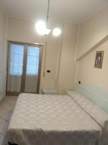 a bedroom with a large bed and a window at Hotel Grazia Ristorante in LʼAquila