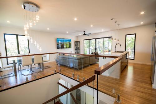 a dining room and living room with a dining table in a house at Beautiful Modern Luxury in Townsville