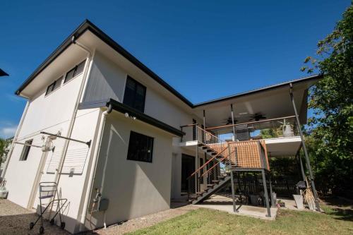 a white house with a staircase and a balcony at Beautiful Modern Luxury in Townsville