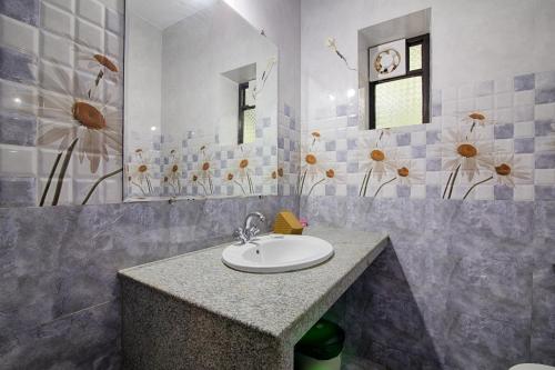 W łazience znajduje się umywalka i lustro. w obiekcie Palm Shades Spring w mieście Benaulim