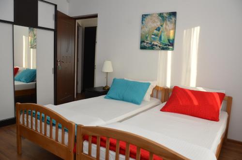 a bedroom with a bed with two colorful pillows on it at California Dreaming in Mamaia Sat/Năvodari
