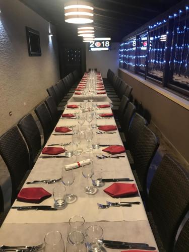 a long table with wine glasses and red napkins at AgriHotel Papaya in San Pietro Apostolo