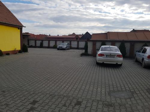 two cars are parked in a parking lot at Hotel Edelweiss in Mediaş