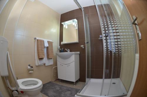 een badkamer met een douche, een toilet en een wastafel bij California Dreaming in Mamaia Nord – Năvodari