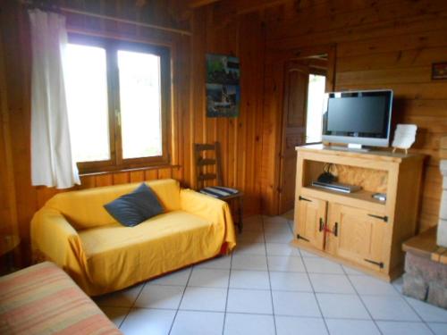 - un salon avec un canapé jaune et une télévision dans l'établissement CHALET du DROPT, à Girmont-Val-d'Ajol