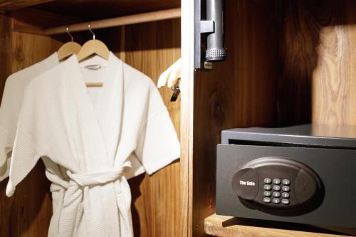 a white robe is hanging next to a microwave at Sanae' Townhouse Chiang Mai in Chiang Mai
