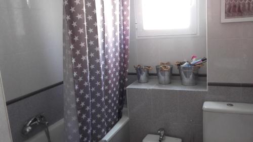 uma casa de banho com um WC e uma cortina de chuveiro em la casa gris em Alicante