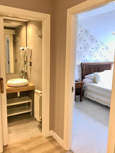 a bathroom with a sink and a bedroom with a bed at Apartamentos Las Vegas in Ribadesella