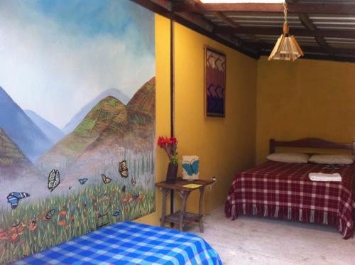 1 dormitorio con una pintura en la pared en Ecovita Organic Lodge & Farm, en Pallatanga