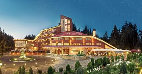 a large building with a garden in front of it at Hotel Yastrebets Wellness & Spa in Borovets