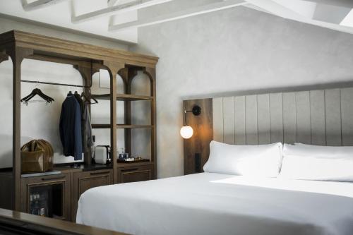 a hotel room with a bed and a dresser at ICON Wipton in Madrid