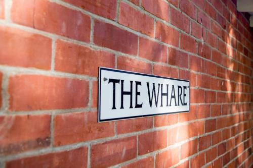 a sign that says the where on a brick wall at Coldstream Estate - The Whare in Coldstream