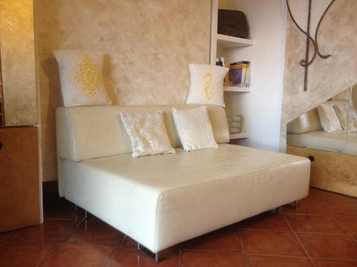 a white couch with pillows on it in a room at Lulamax Sardegna in Budoni