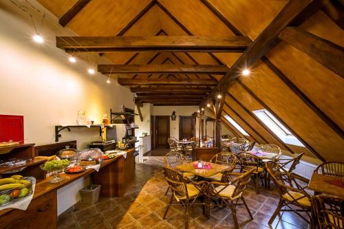 eine Küche und ein Esszimmer mit Holzdecken und Tischen in der Unterkunft Arcadie Hotel & Apartments in Český Krumlov