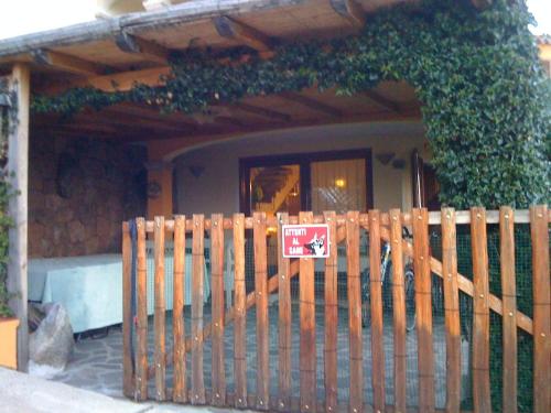 a wooden fence with a no dogs sign in front of a house at Lulamax Sardegna in Budoni