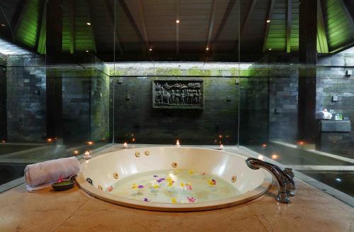 Finna Golf & Country Club في بريغين: حوض استحمام في الحمام مع شموع