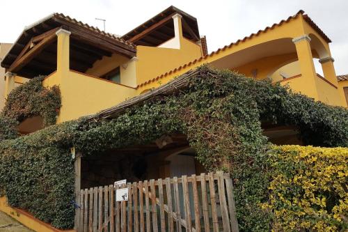 a yellow house with ivy growing on it at Lulamax Sardegna in Budoni