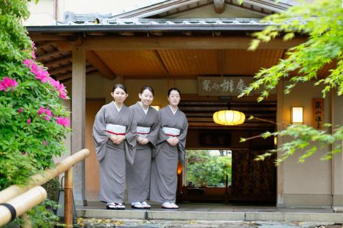 a group of three women standing in front of a building at Arashiyama Benkei in Kyoto