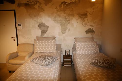 a bedroom with two twin beds and a chair at Masone Home in Modena