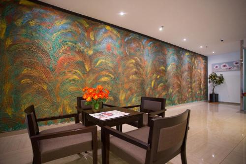 a dining room with a large painting on the wall at 7 Heaven Boutique Hotel in Pasir Gudang