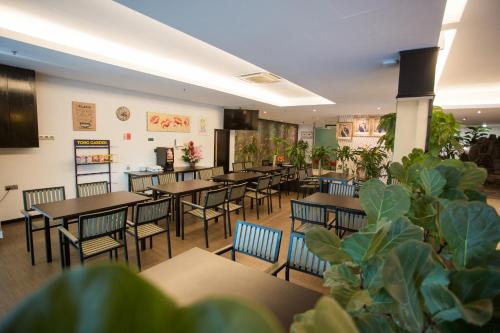 a dining room with tables and chairs and plants at 7 Heaven Boutique Hotel in Pasir Gudang