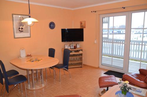 a living room with a table and a television at Ferienwohnung Fischerhafen 14/Guent in Ostseebad Karlshagen