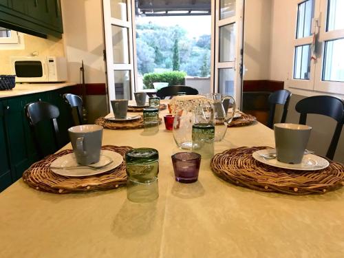 a table with plates and glasses on top of it at Vrontados Villa in Vrontados