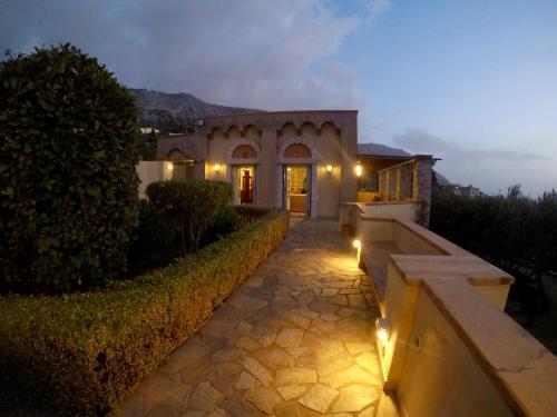 a house with a pathway in front of a building with lights at Vrontados Villa in Vrontados