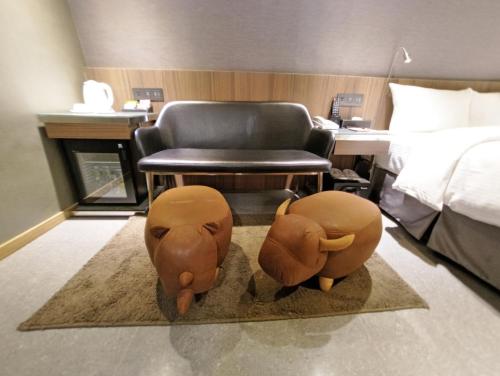 two elephant statues in a hotel room with a chair at Beauty Hotels Taipei - B7 Journey in Taipei