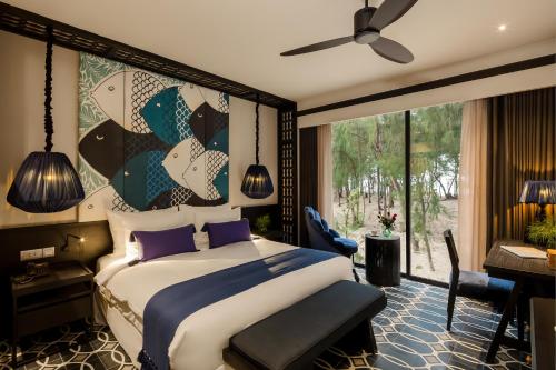 a bedroom with a bed and a large window at Sol An Bang Beach Resort & Spa in Hoi An