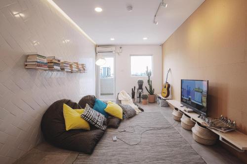 a living room with a couch and a flat screen tv at Konko Hostel Jakarta in Jakarta