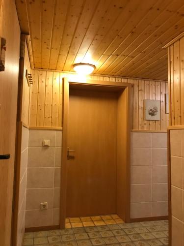 een badkamer met een bruine deur in een kamer bij Schönes Kellerzimmer mit Bad in Mittelangeln