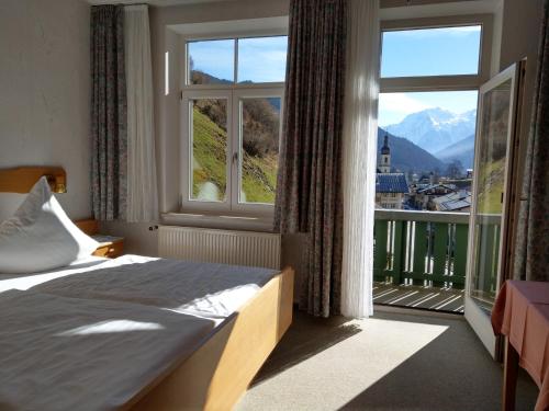 a bedroom with a bed and a large window at Gasthof Oberwirt in Ramsau